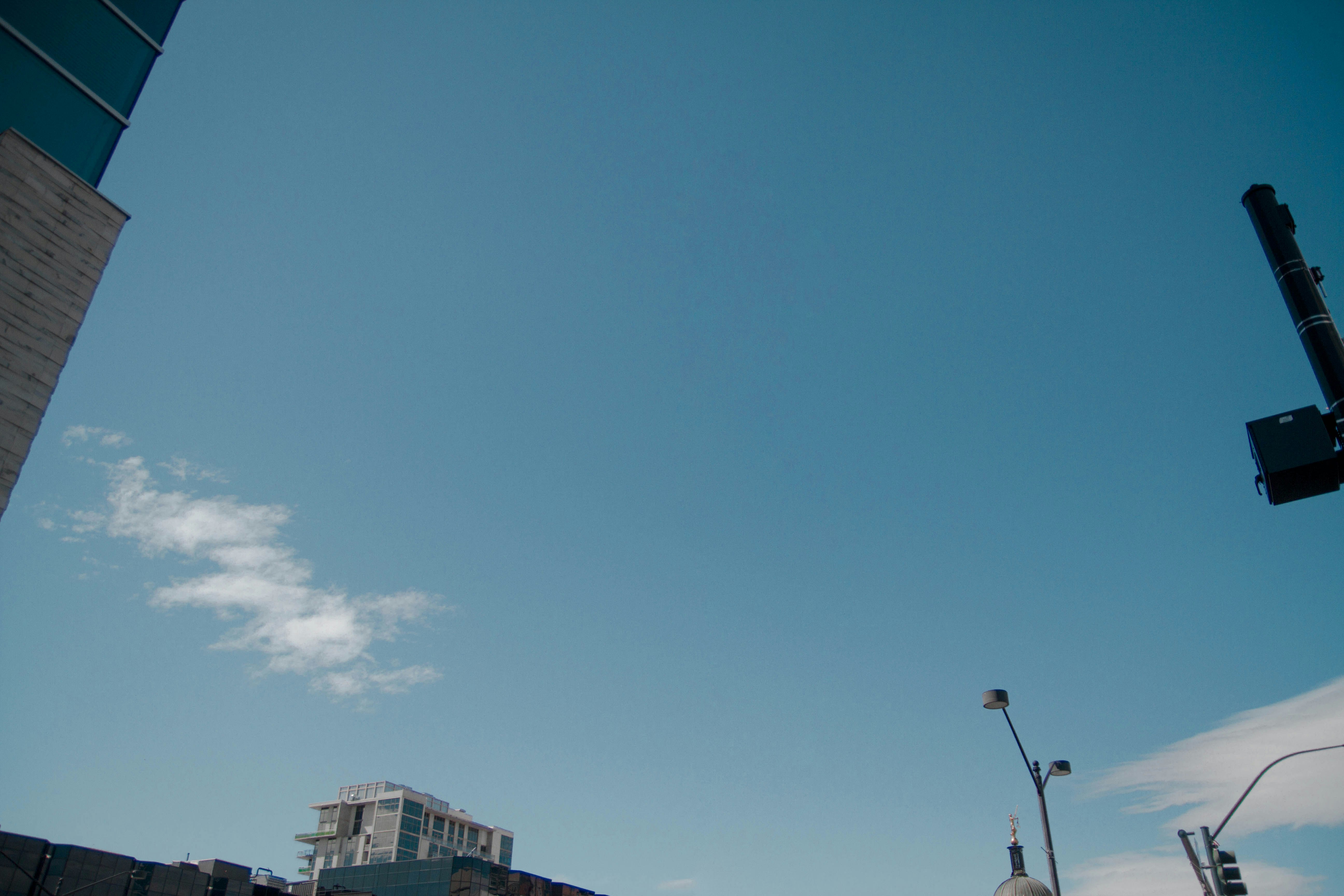 gray building under blue sky and white clouds during daytime